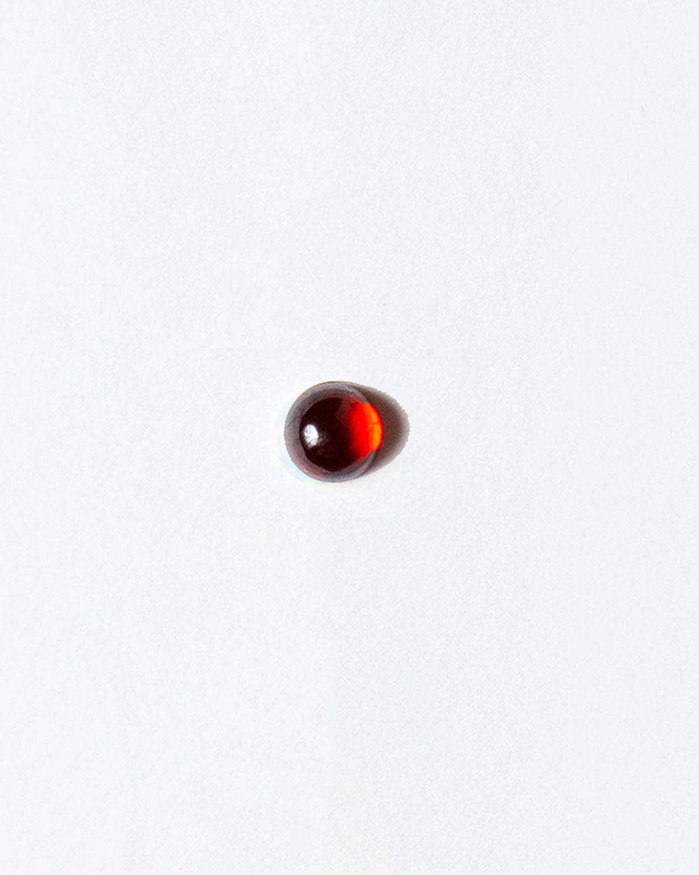 Garnet cabochon on light color background.
