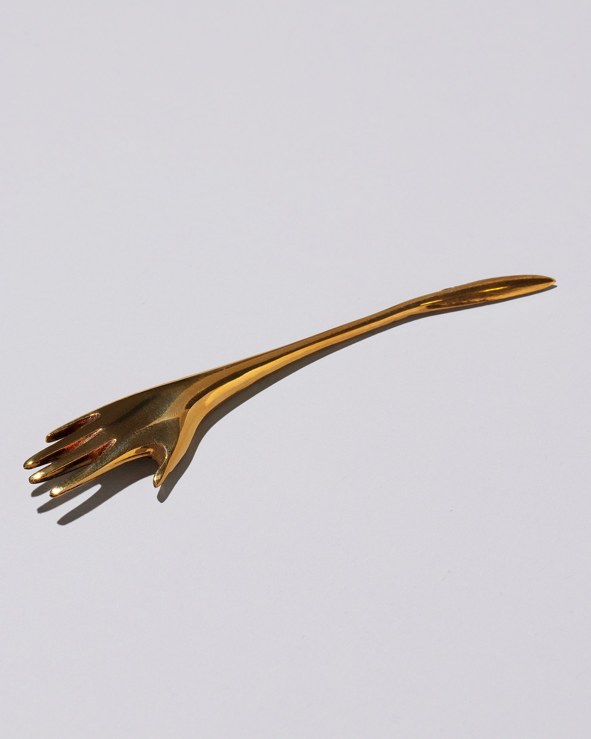 View from the side of the Carl Auböck Brass Hand Letter Opener on light color background.