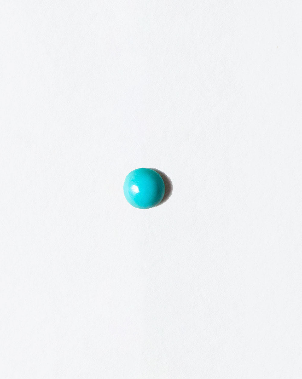 Turquoise cabochon on light color background.