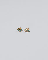 Gold Eye See You Stud Earrings on light color background.