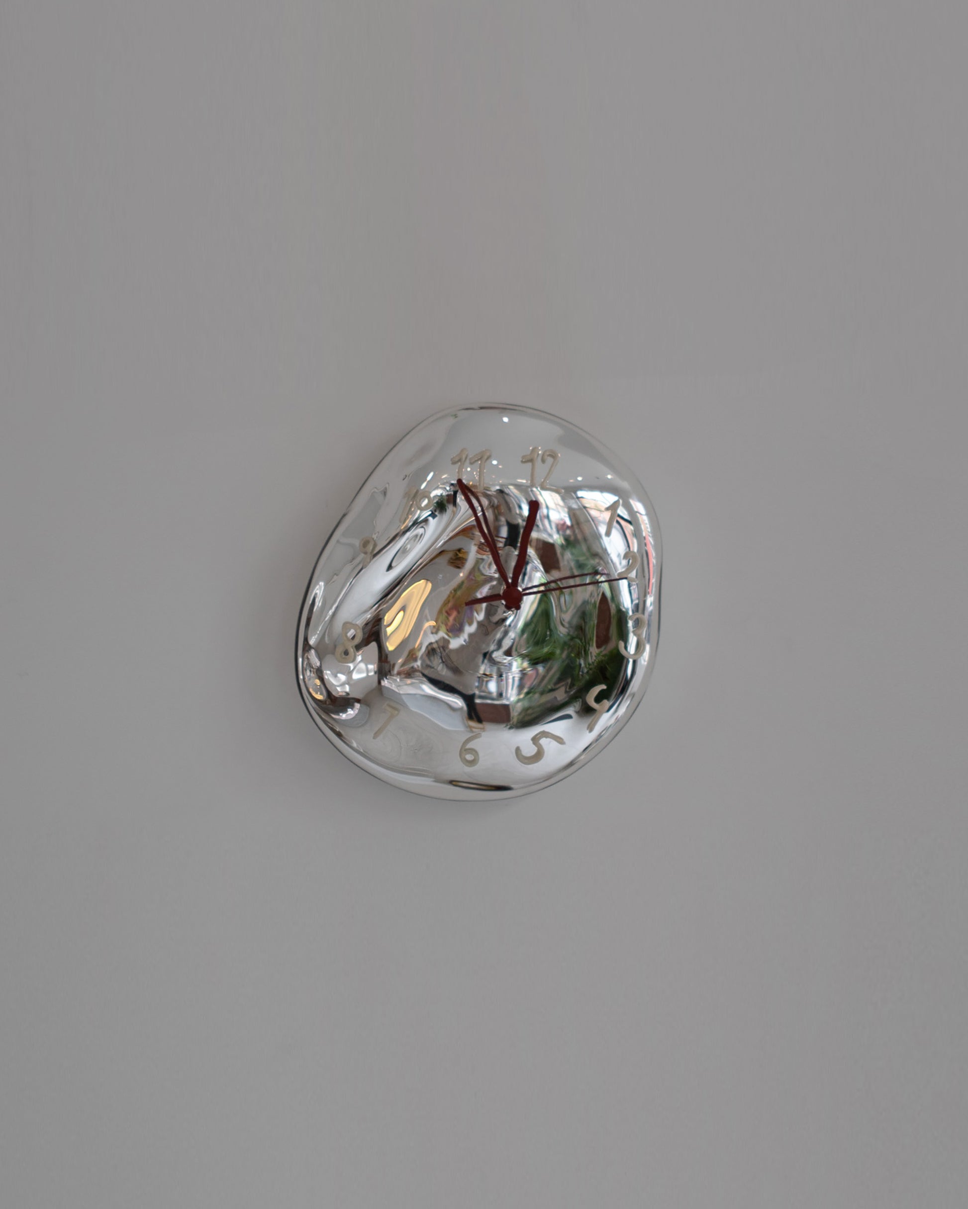 Silje Lindrup Red Hands White Glass Wall Clock on light color background.