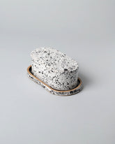 Recreation Center Black Butter Dish on light color background.