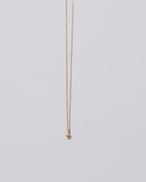 Tear Talisman Pendant Necklace on light color background.
