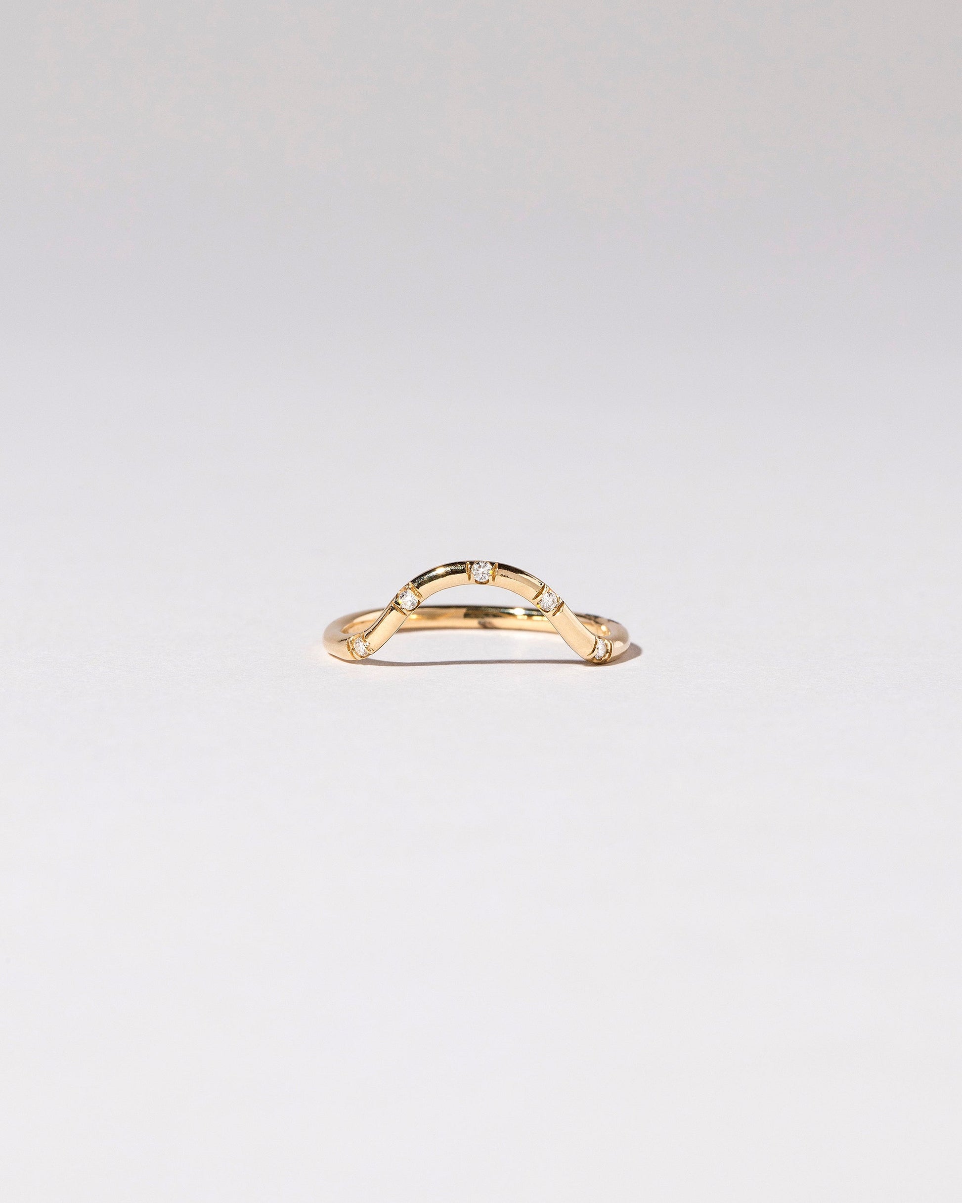 Gold White Diamond Five Stone Curve Band on light color background.