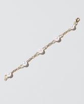 Five Pearl Station Bracelet Hot Dog Chain on light color background.