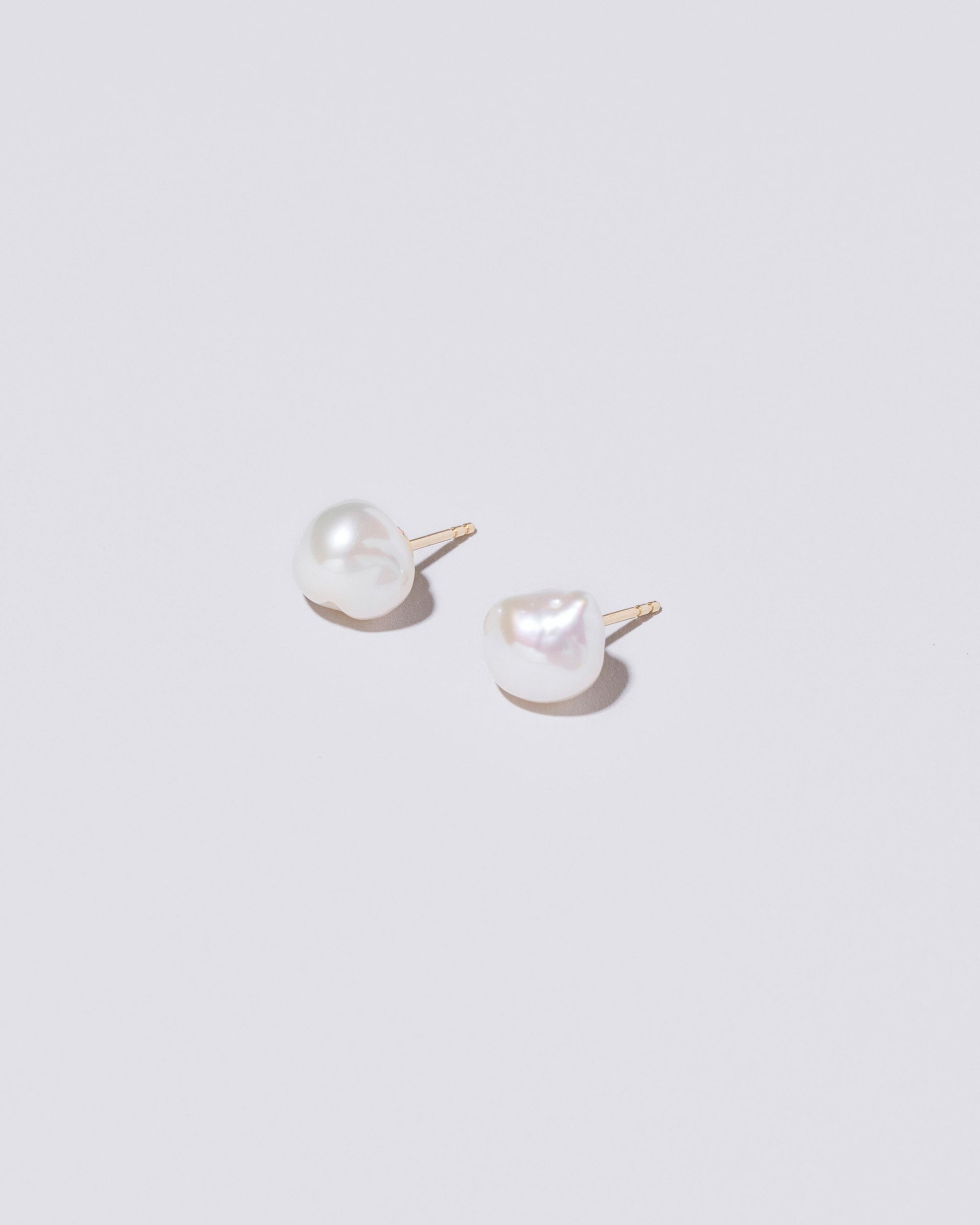 Lagniappe Pearl Stud Earrings on light color background.