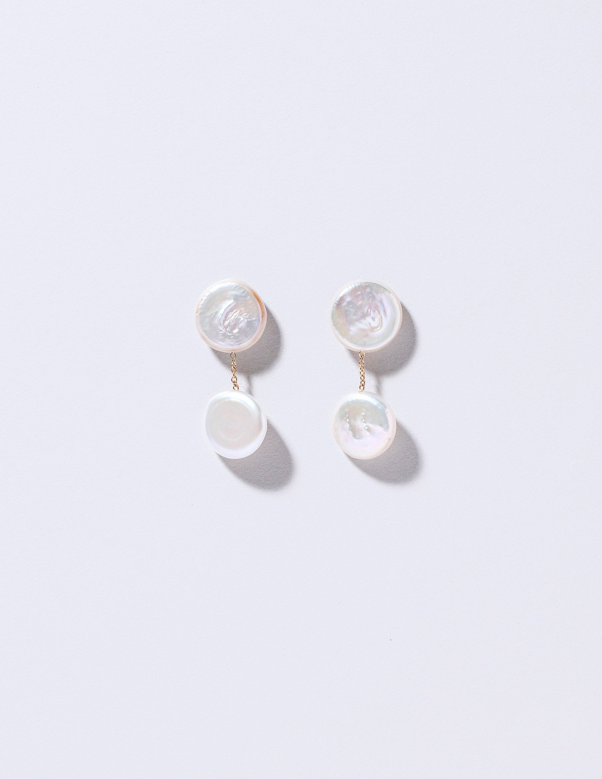 Atlas Earrings on light color background.