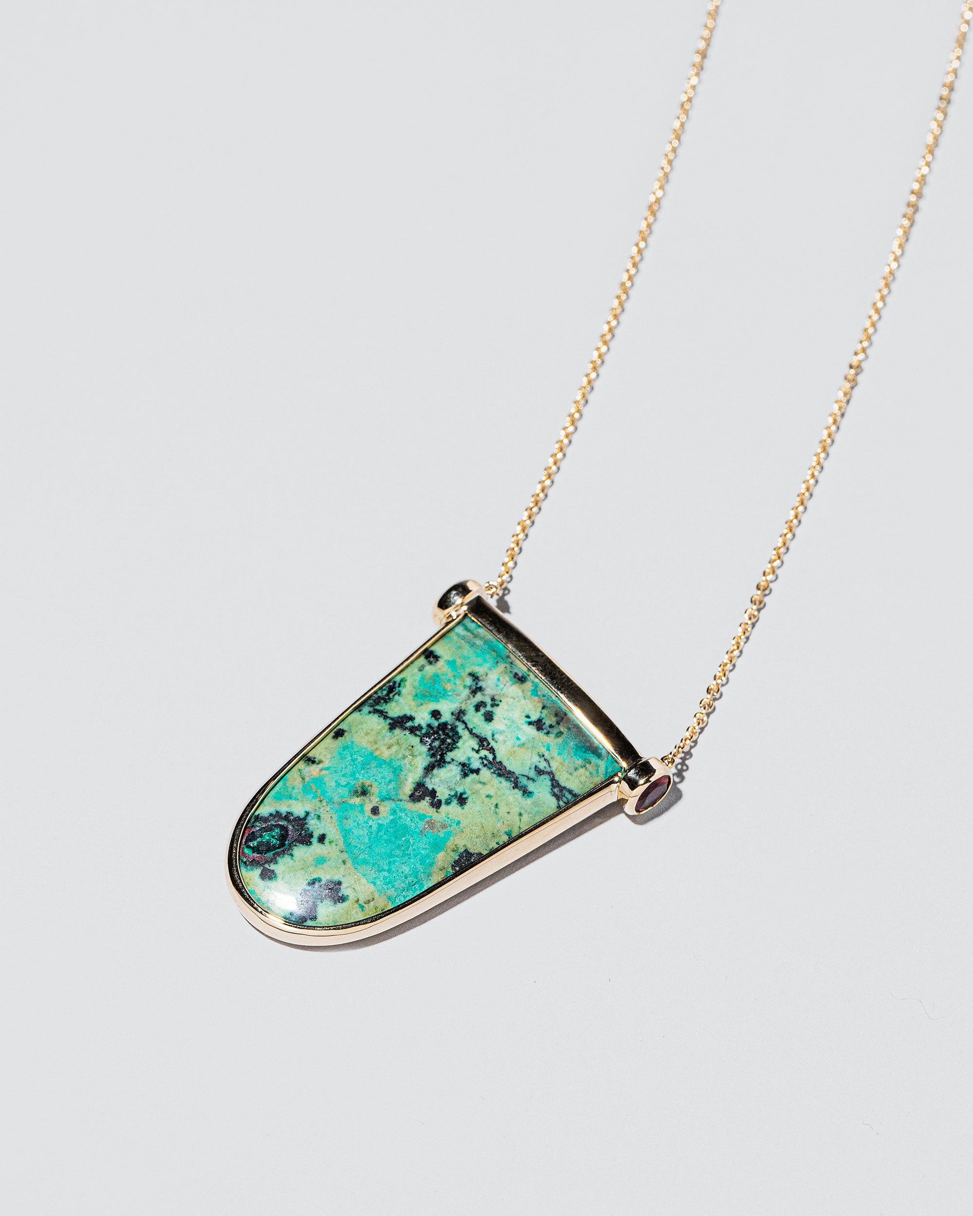 Chrysocolla Tongue Necklace on light color background.