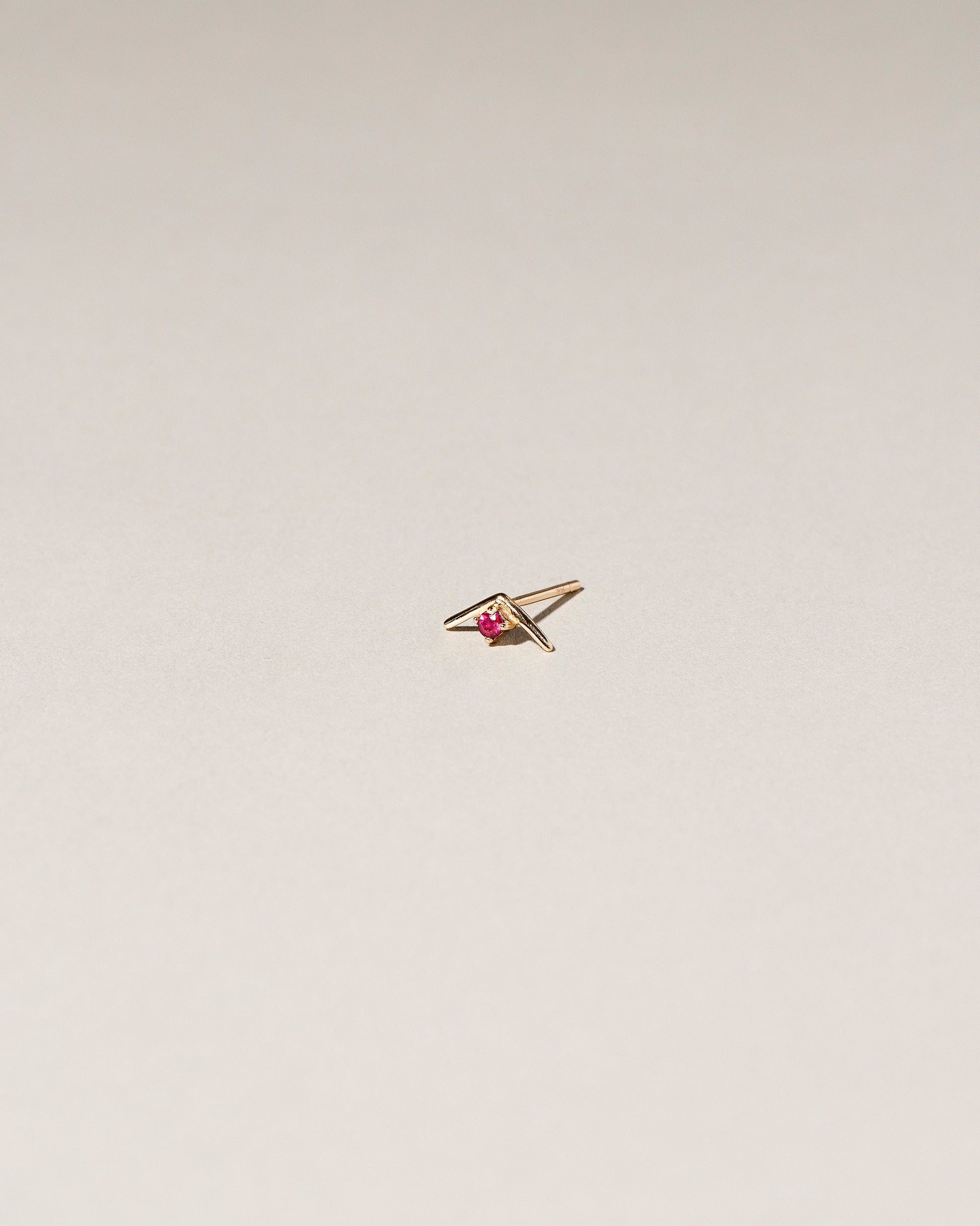 Gold Ruby Sun Catcher Stud Earring Single on light color background.