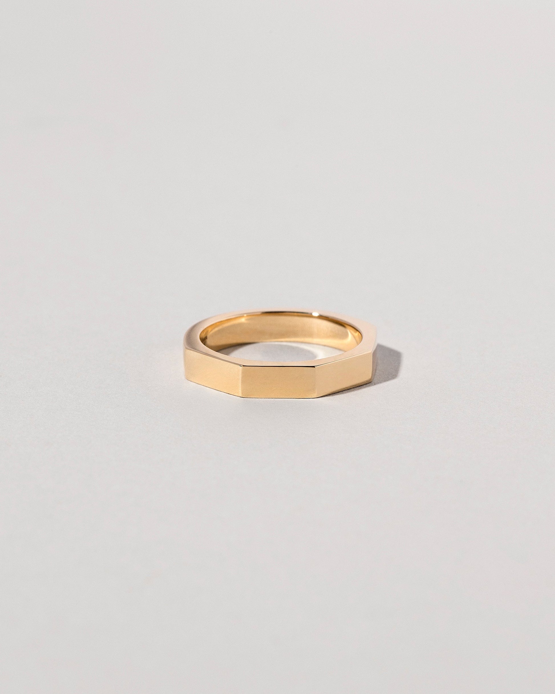 Closeup details of the Gold 4mm Segmented Half Hoop Band on light color background.