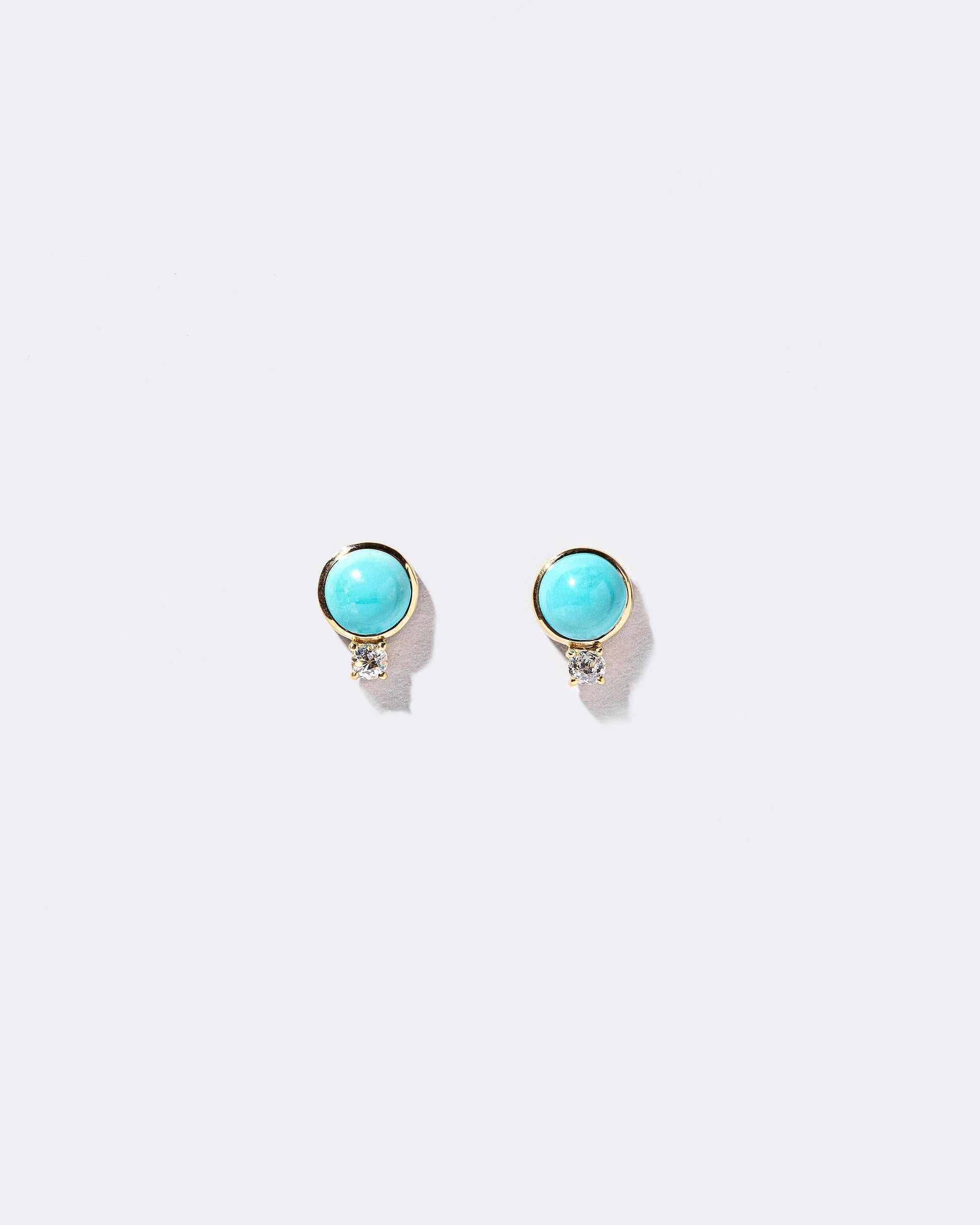In-Between Earrings on light color background.