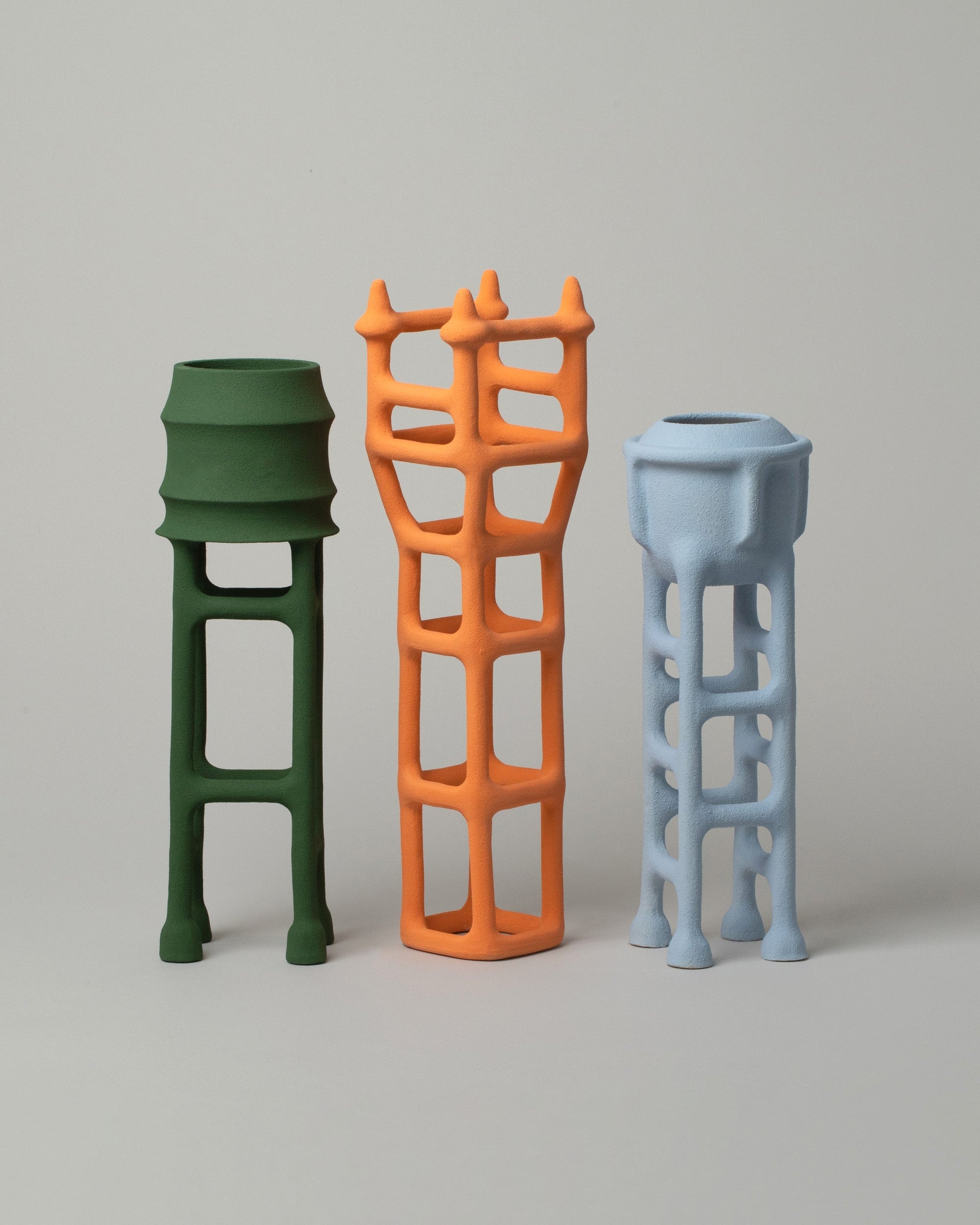  Group photo of Solenne Belloir Forest Green, Orange, and Pale Blue Water Towers on light color background.