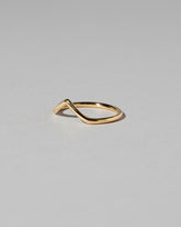 View from the side of the Gold Solid Round Wire High Peak Band on light color background.