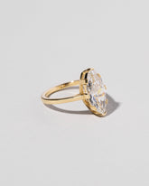 View from the side of the North-South Navette Diamond Solitaire Ring on light color background.