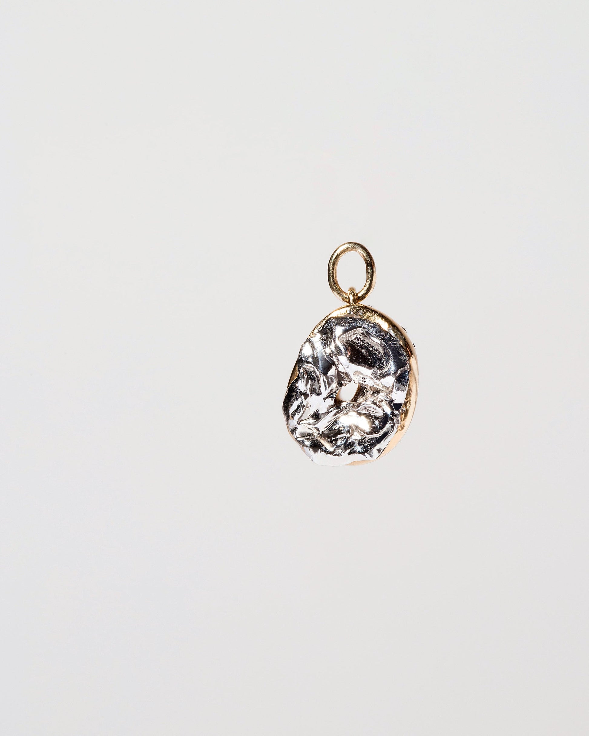 Poppy Seed Bagel Charm with Cream Cheese on light color background.