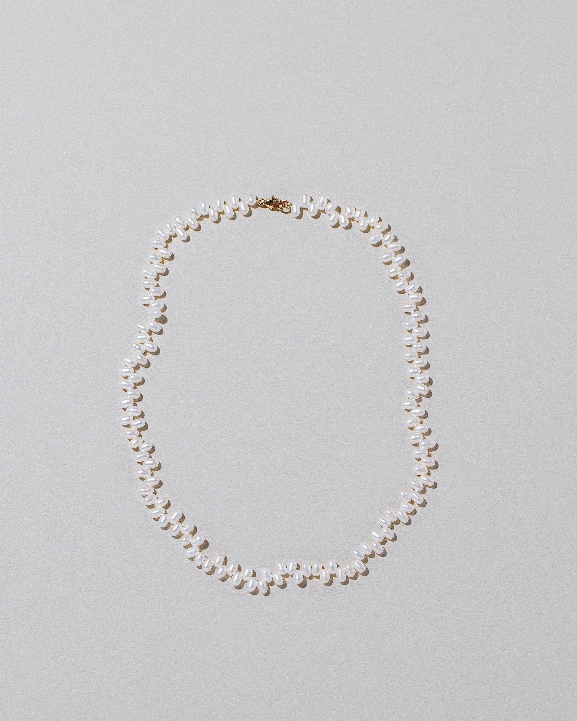 Small Zipper Pearl Necklace on light color background.