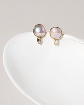 Mabe Pearl & Diamond Earrings on light color background.