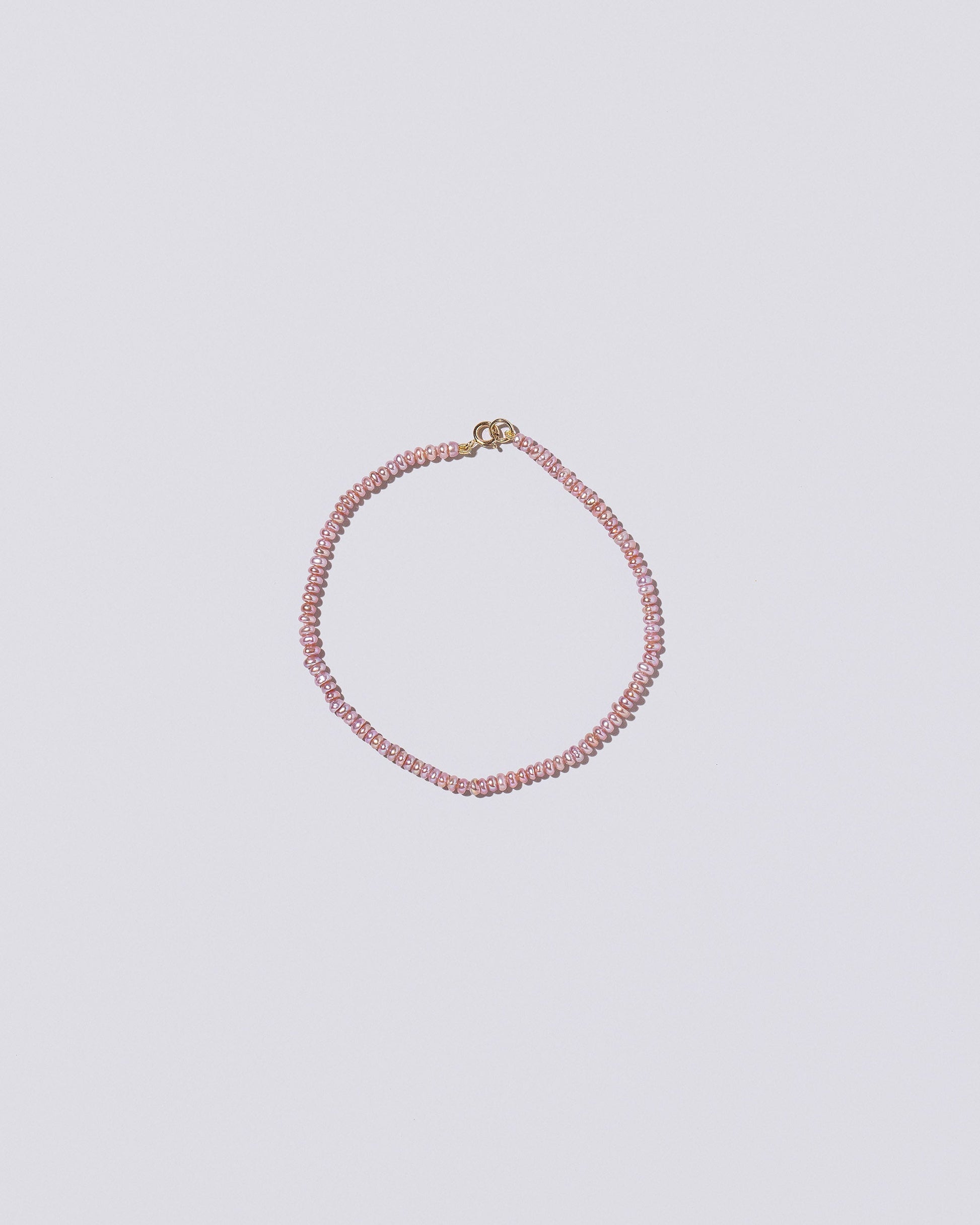 Pink Lavender Seed Pearl Bracelet on light color background.