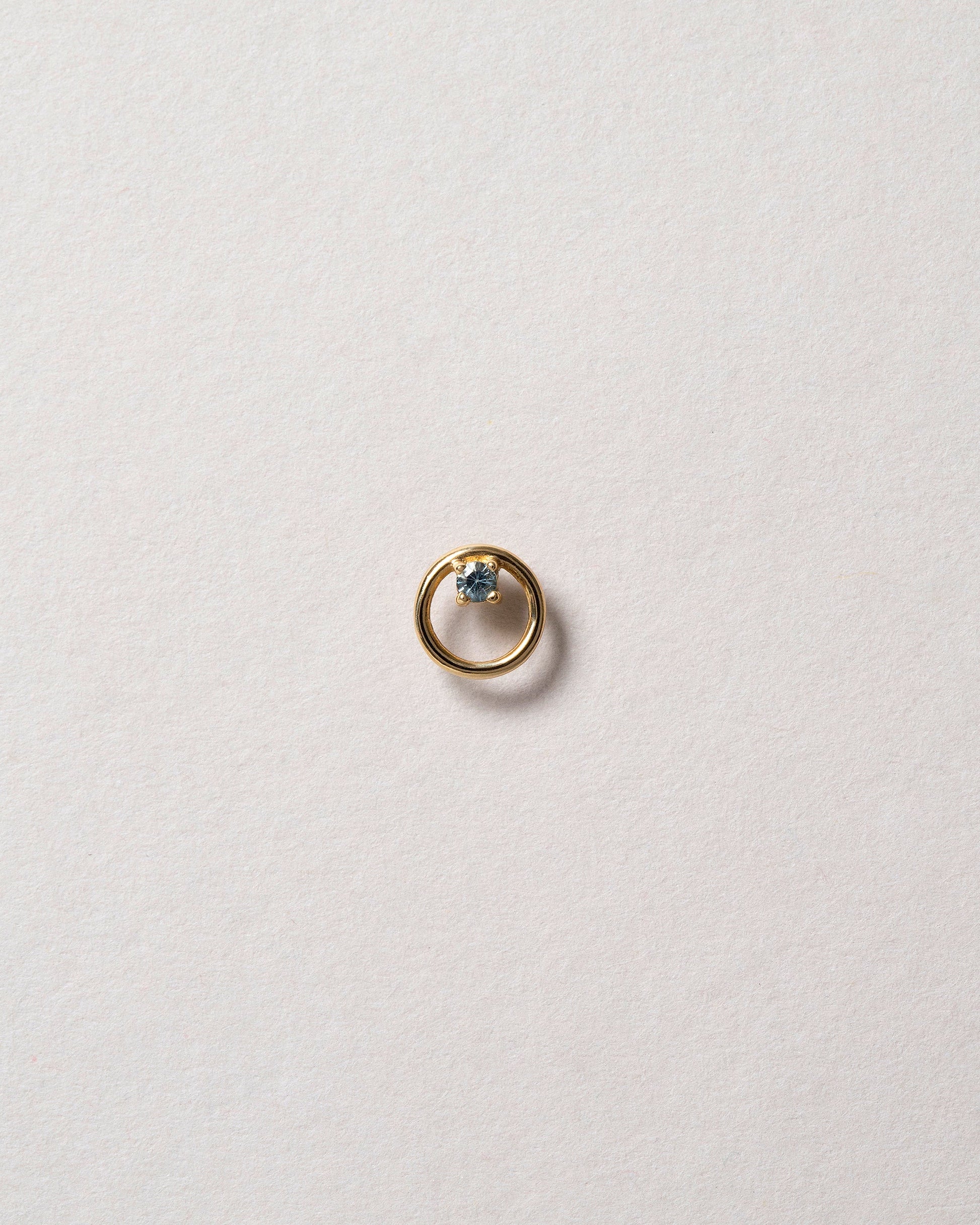 Gold Blue Sapphire Full Moon Stud Earring Single on light color background.