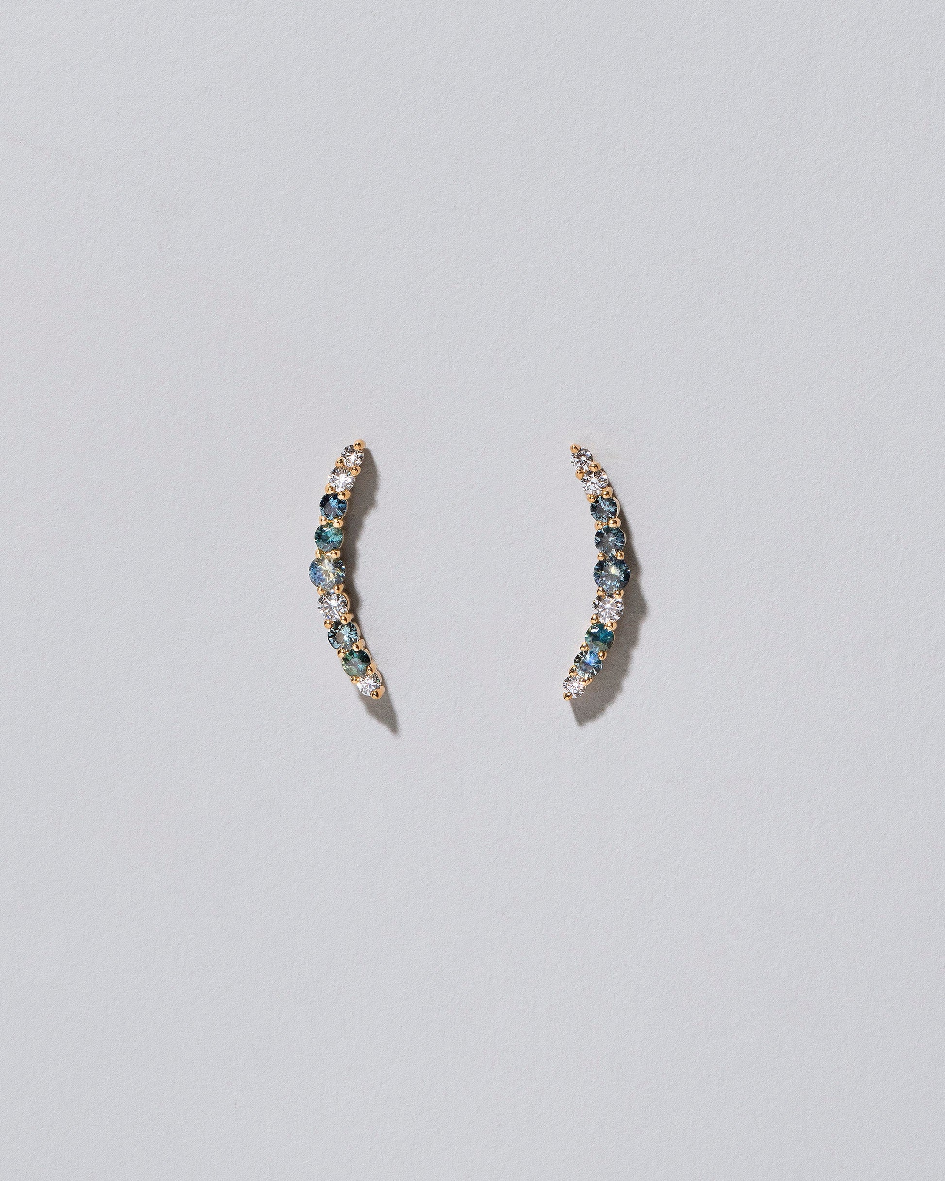 Crescent Ear Climber Stud Earrings - Sapphier and White Diamond on light colored background.