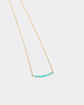 Closeup detail of the Turquoise Crescent Necklace on light color background.