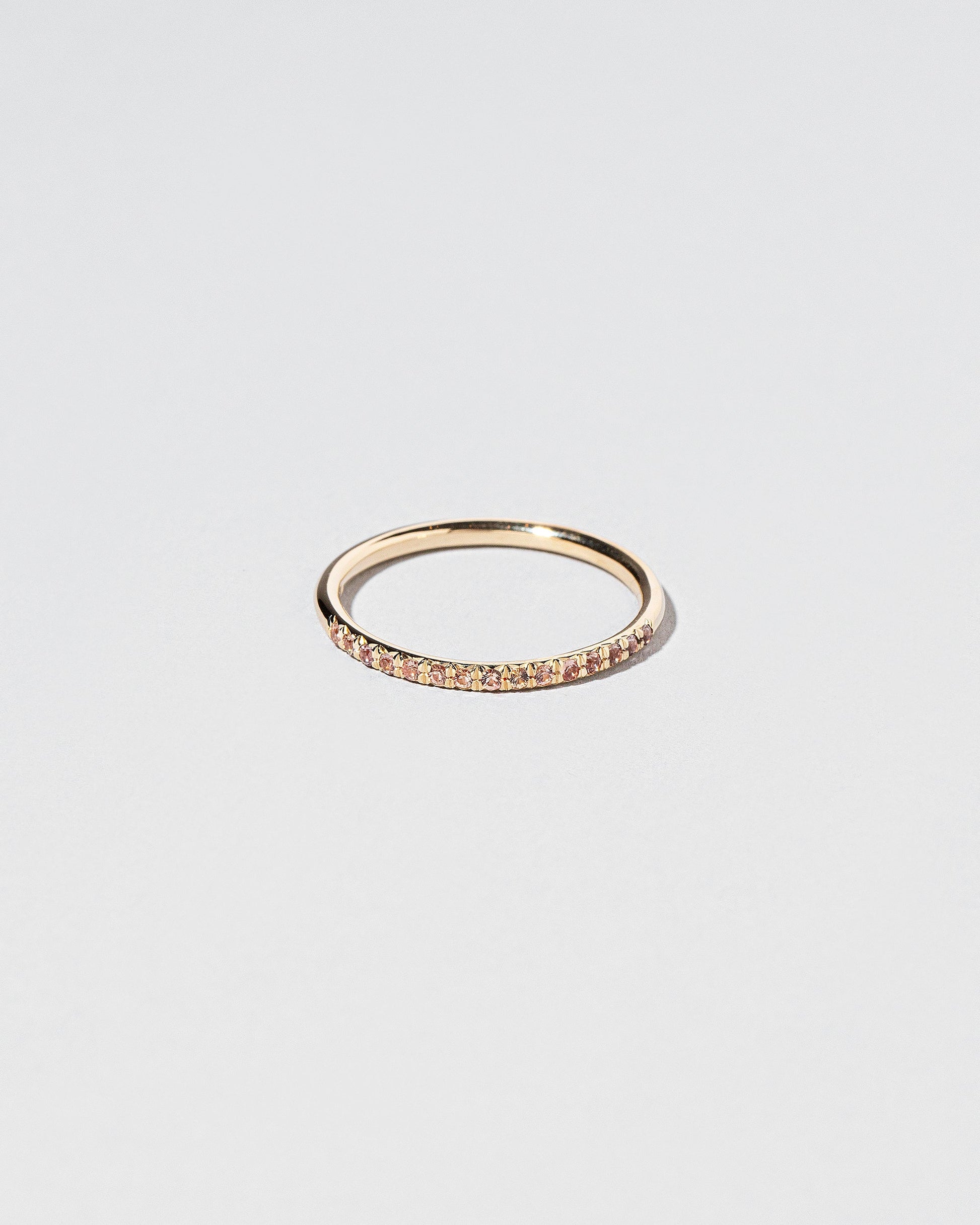 Gold Peach Malawi Sapphire Fifteen Stone Dot Band on light color background.