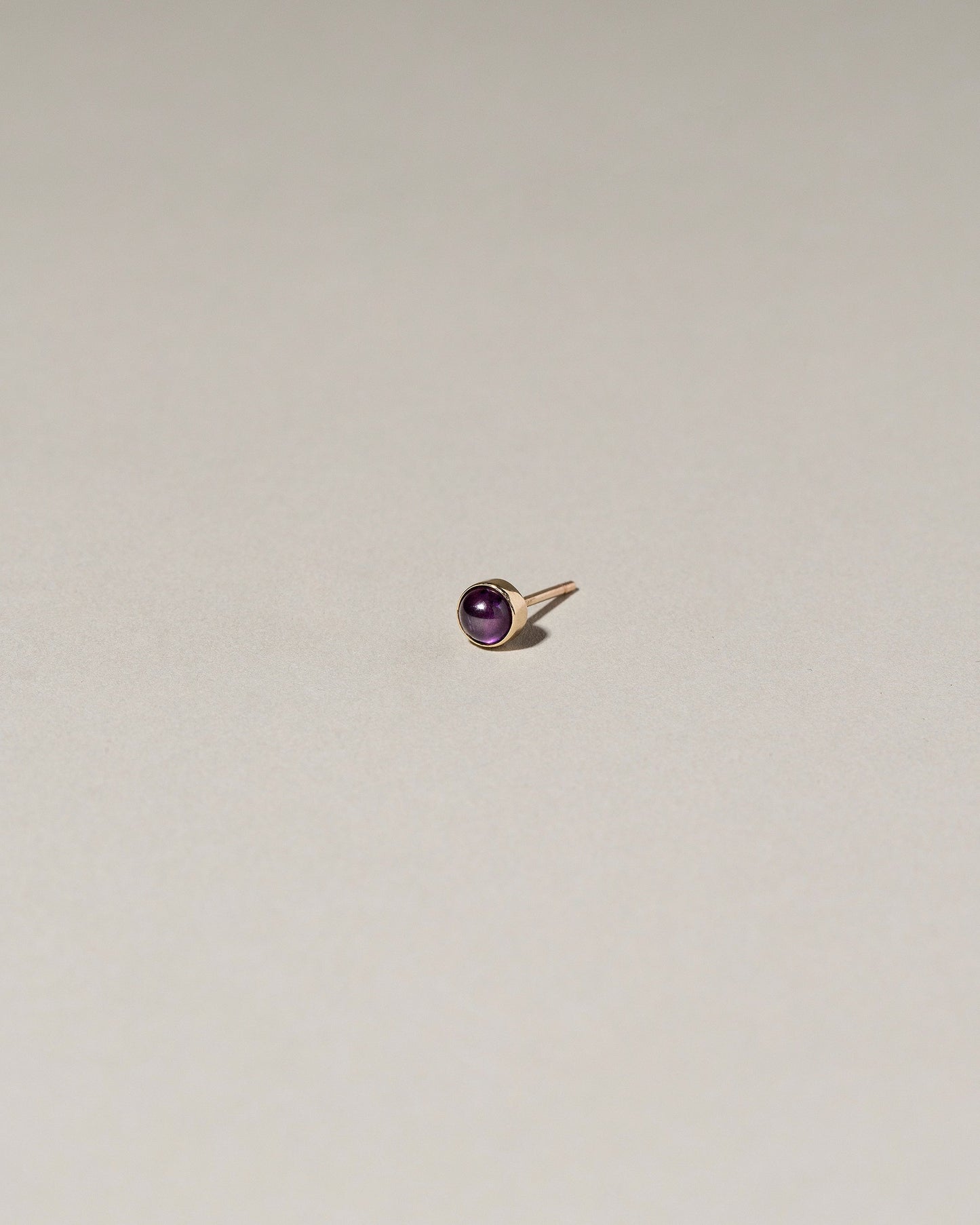 Birthstone Single Stud on light color background.