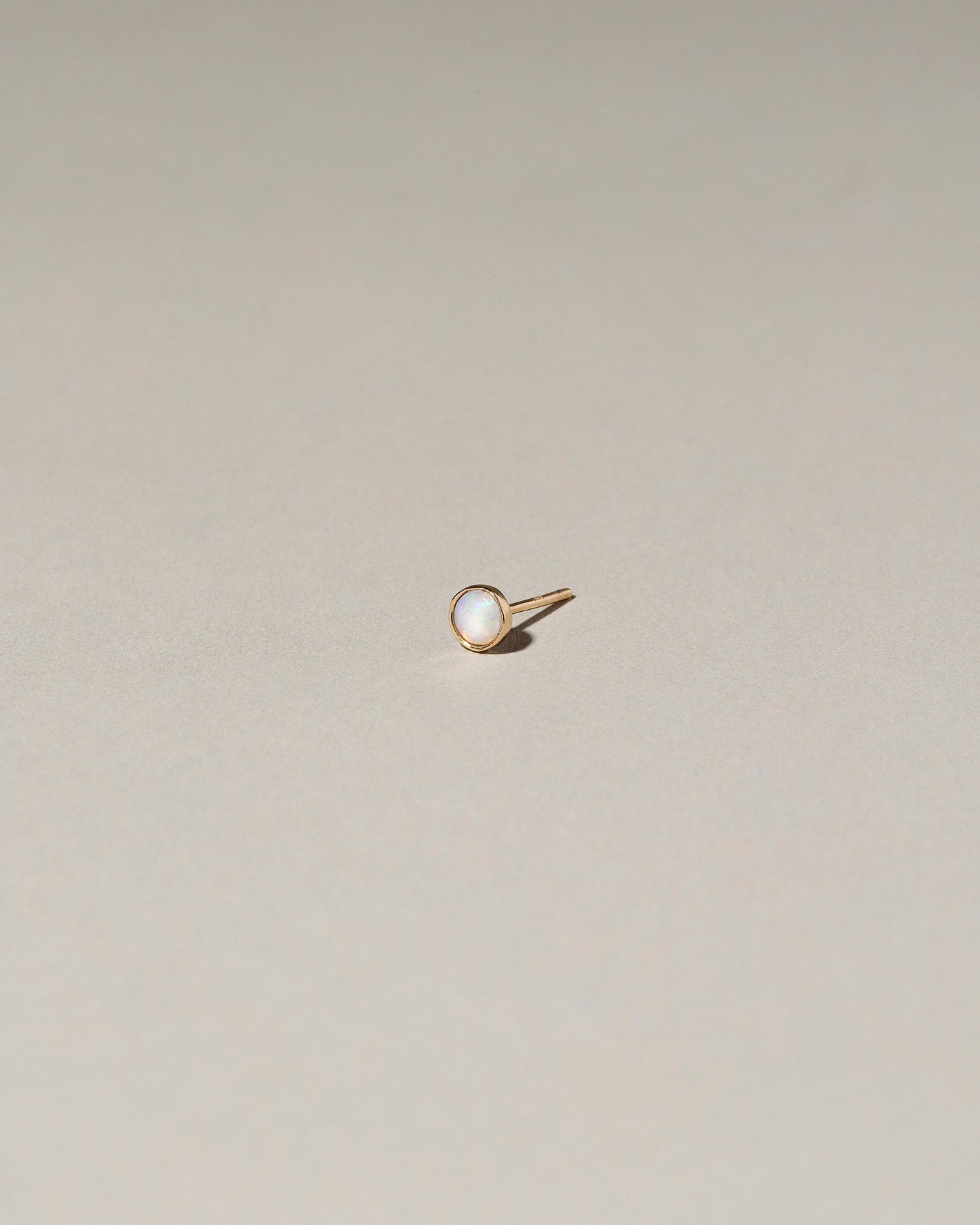 Birthstone Single Stud on light color background.