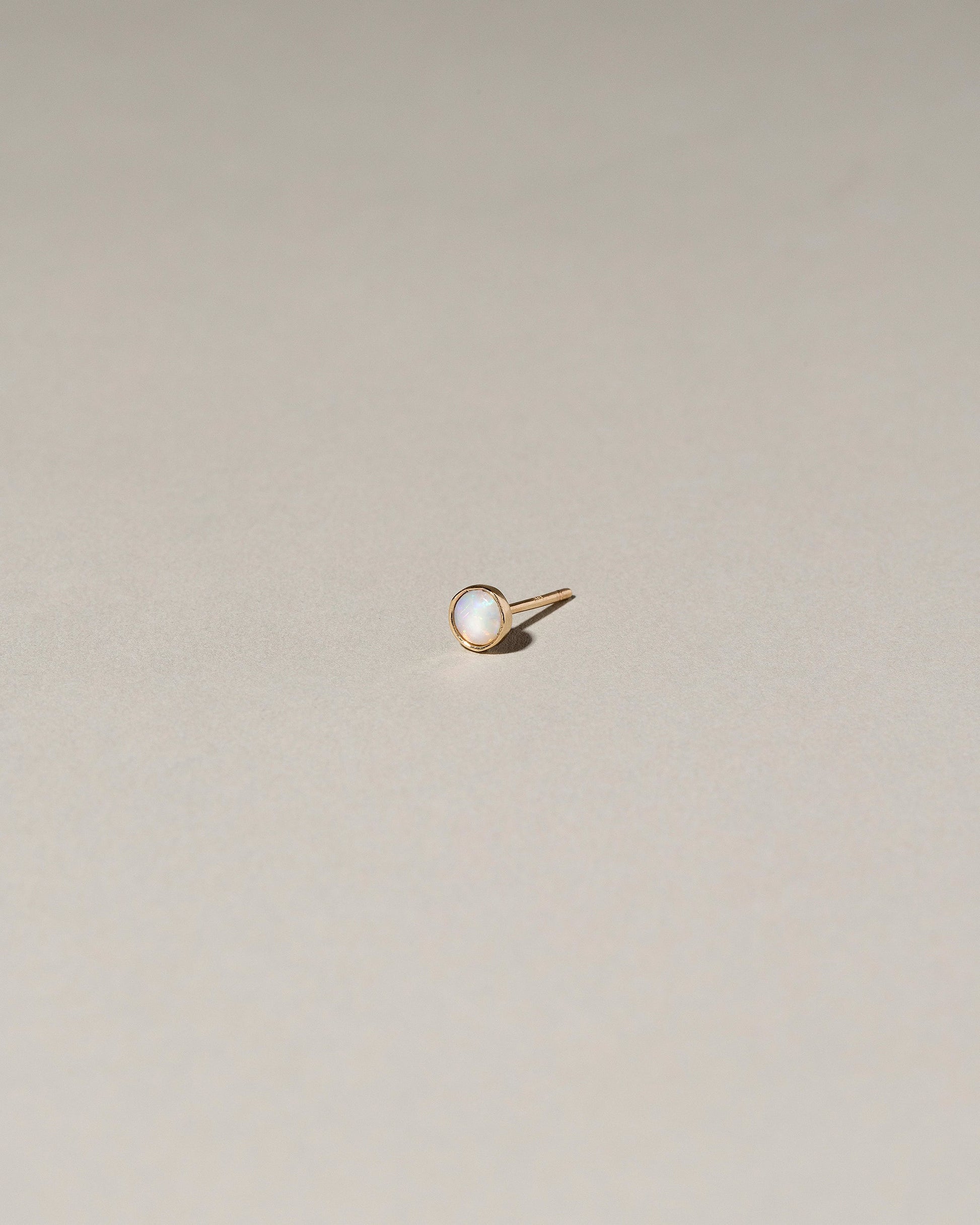 Birthstone Single Stud on light color background.