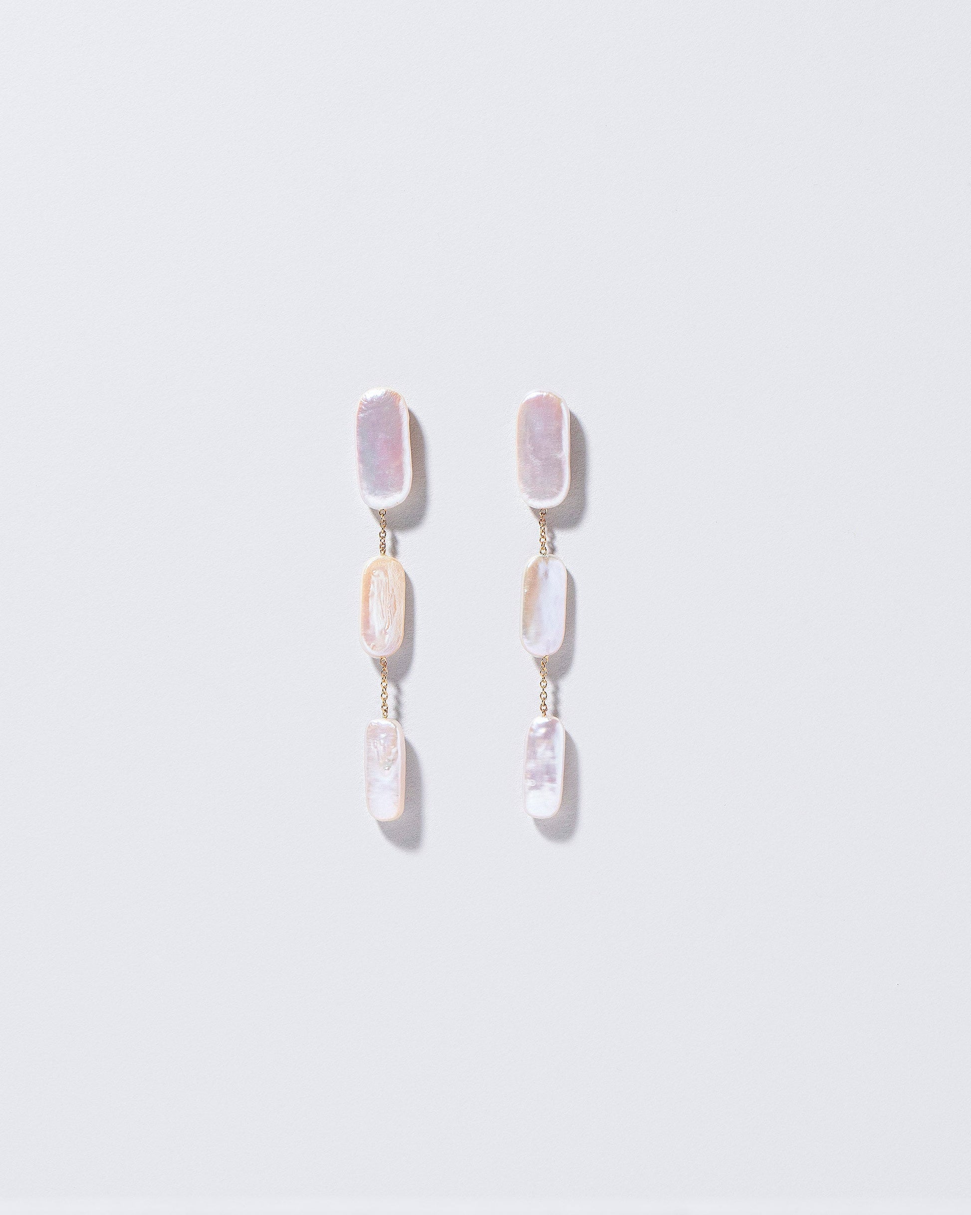 Pelias Earrings on light color background.