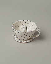 Closeup detail of the Eleonor Boström Spotty Dog Tea Cup & Saucer on light color background.