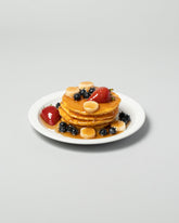 Spills Pancakes with Fruit Pancakes & Waffles on light color background.