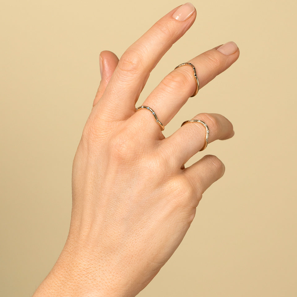 product_details::Gold Five Stone Mini Curve Bands on model.