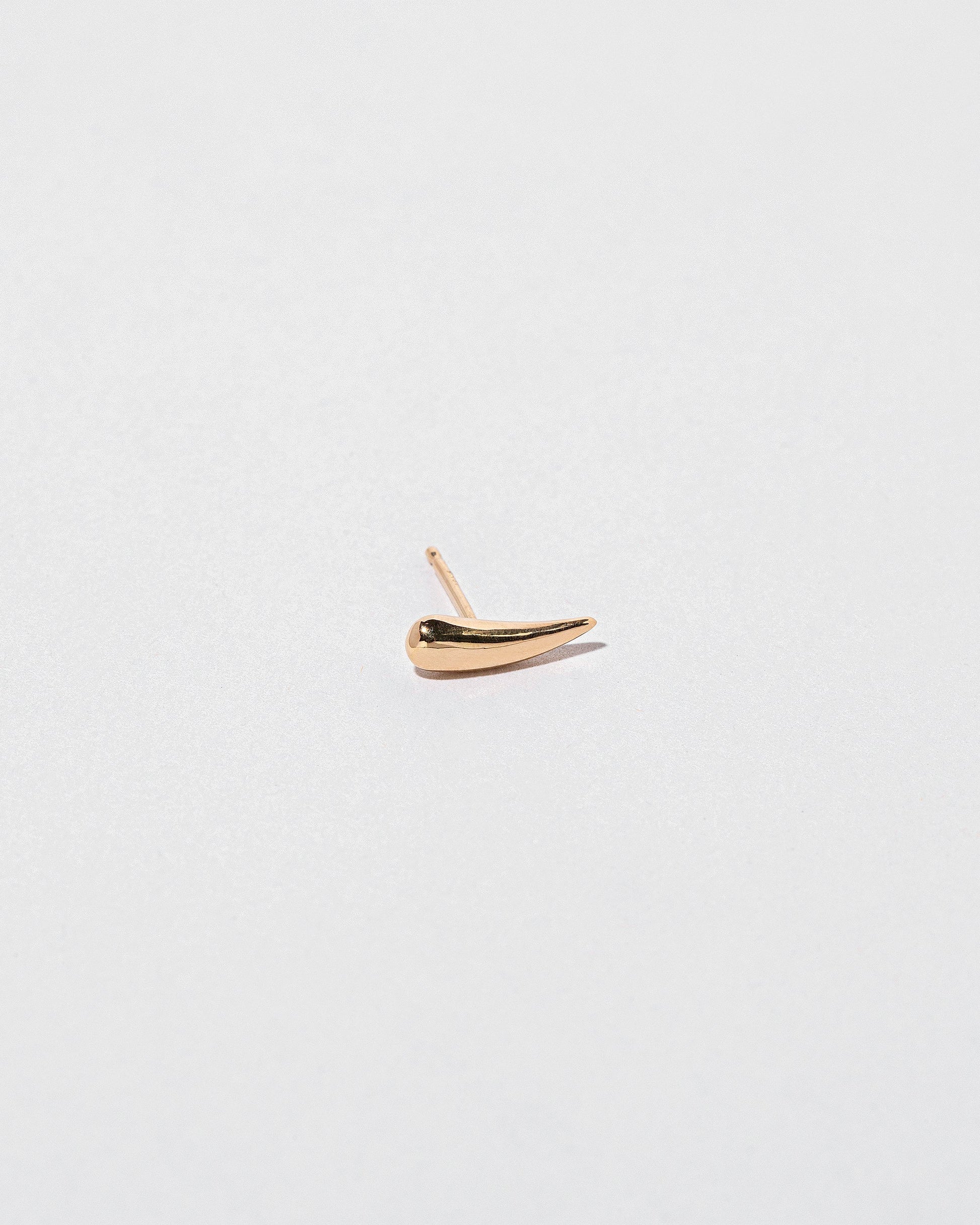 Gold Solid Right Facing One & Others Stud Earring Single on light color background.