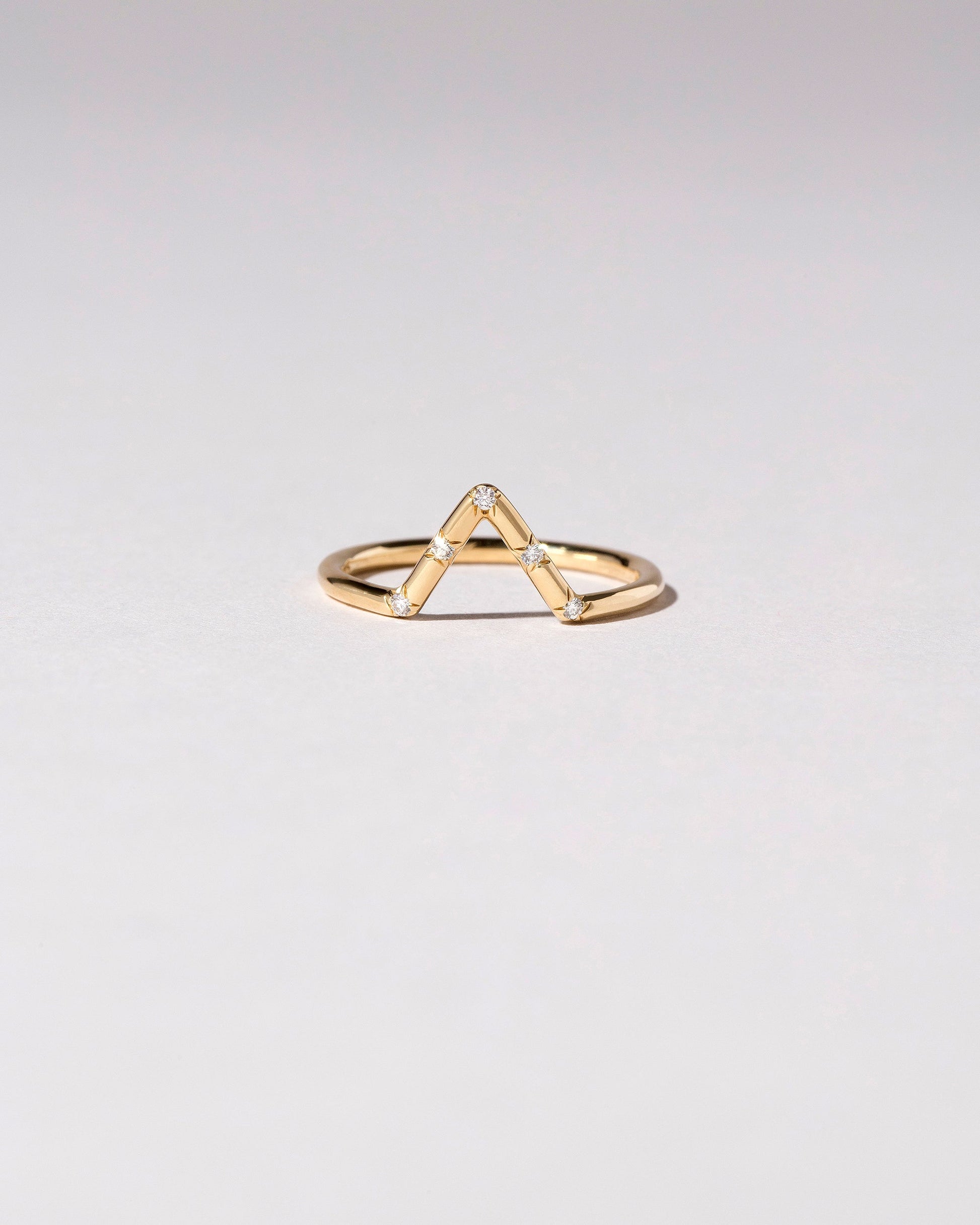 Gold White Diamond Five Stone Triangle Band on light color background.
