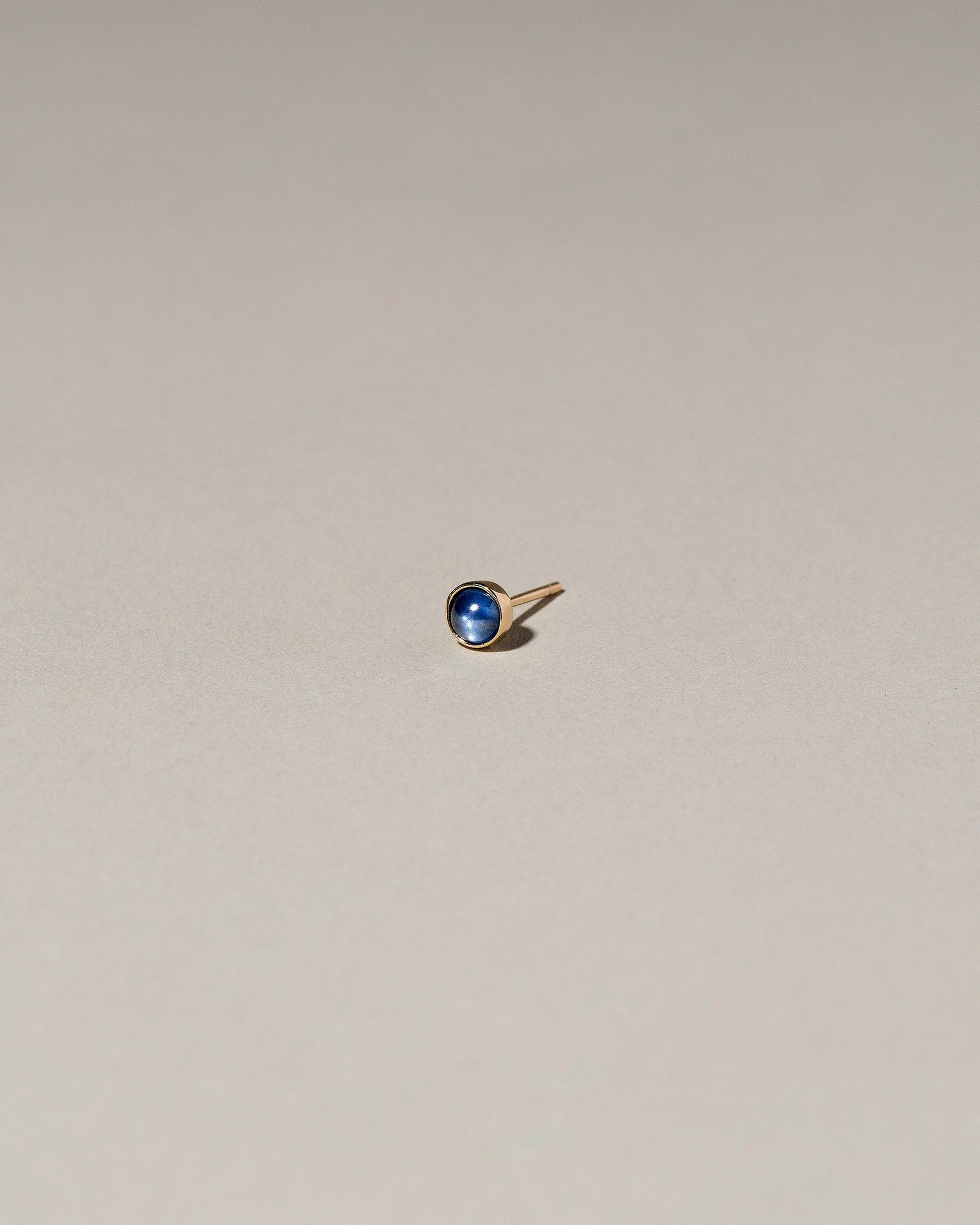 Birthstone Single Stud on light color background.