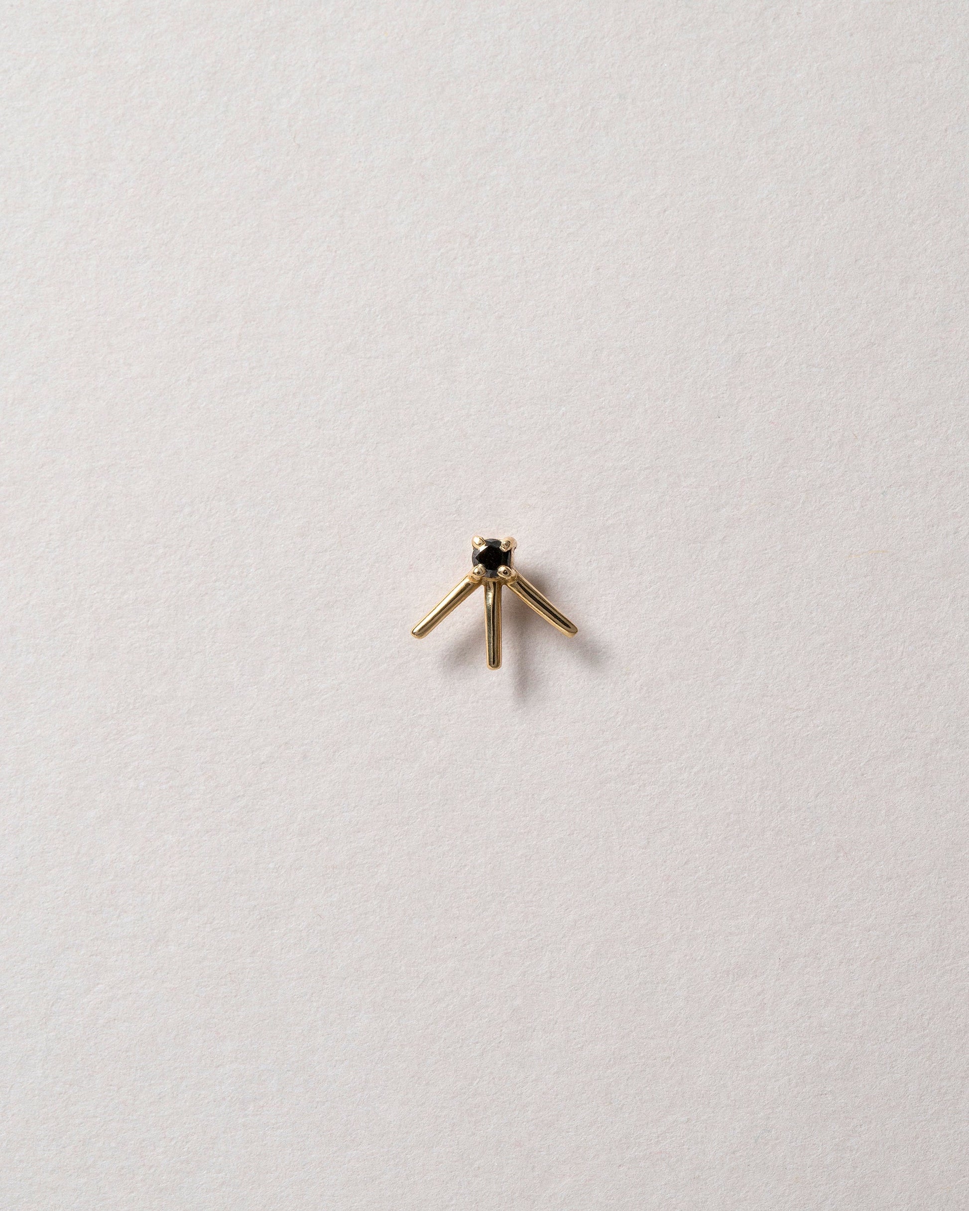 Gold Black Diamond Stud Earring Single on light color background.