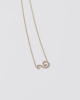 White Diamond Symbol of Change Necklace on light color background.