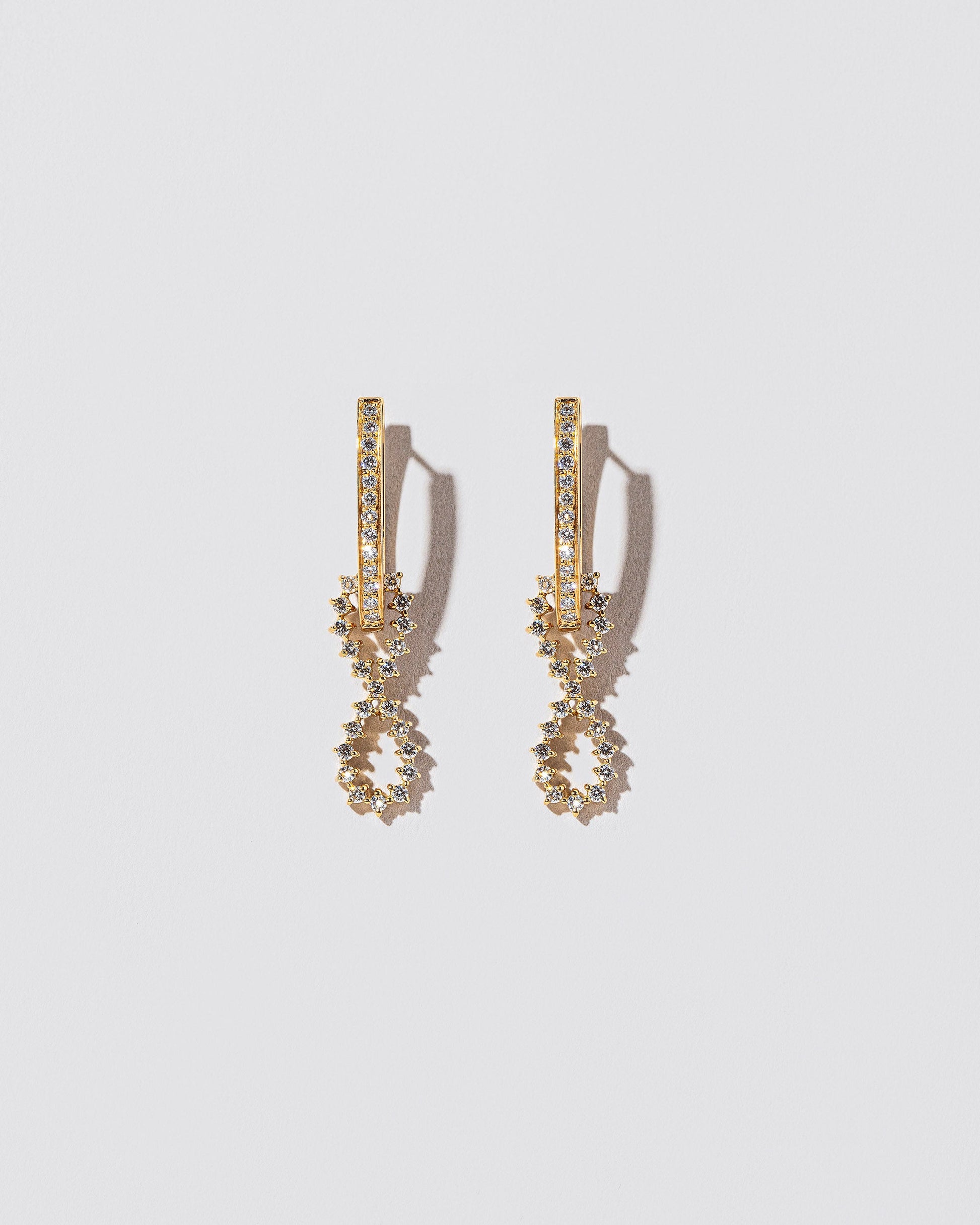 White Diamond Lifecycle Earrings on light color background.