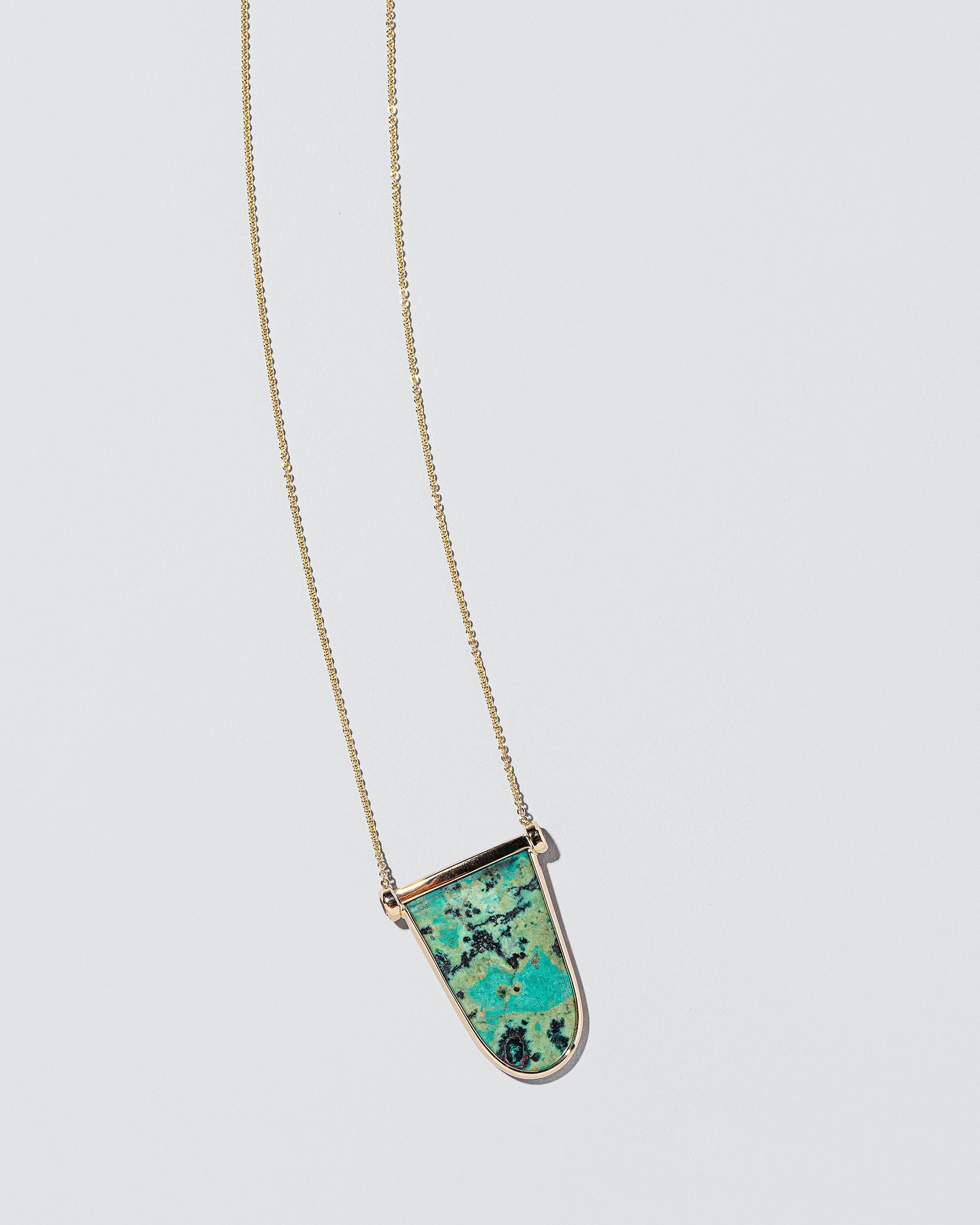 Chrysocolla Tongue Necklace on light color background.