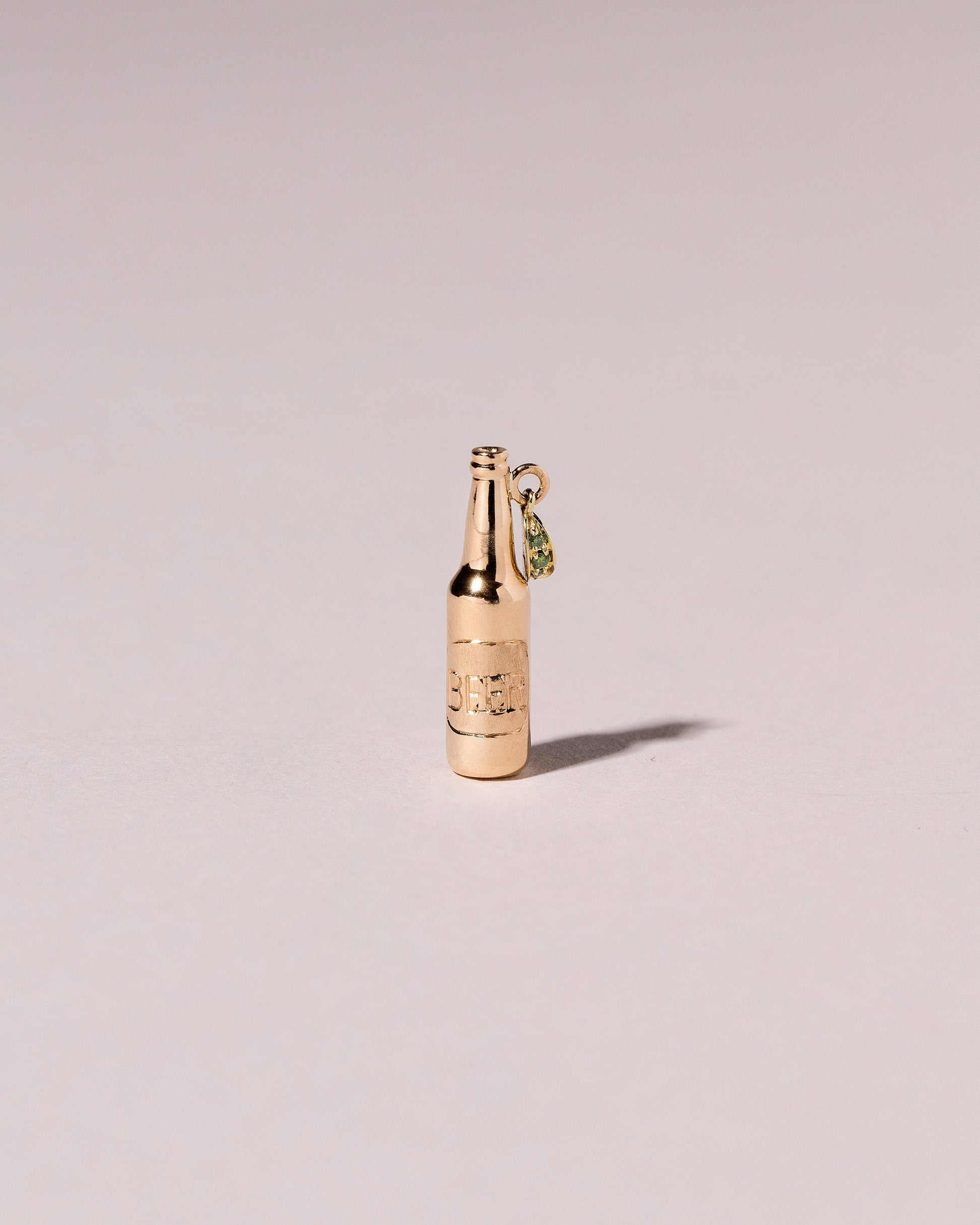 Bottle of Beer Charm on light color background.