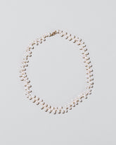 Large Zipper Pearl Necklace on light color background.