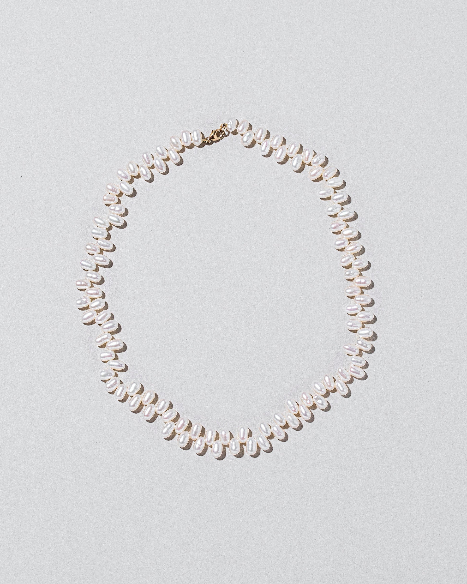 Large Zipper Pearl Necklace on light color background.