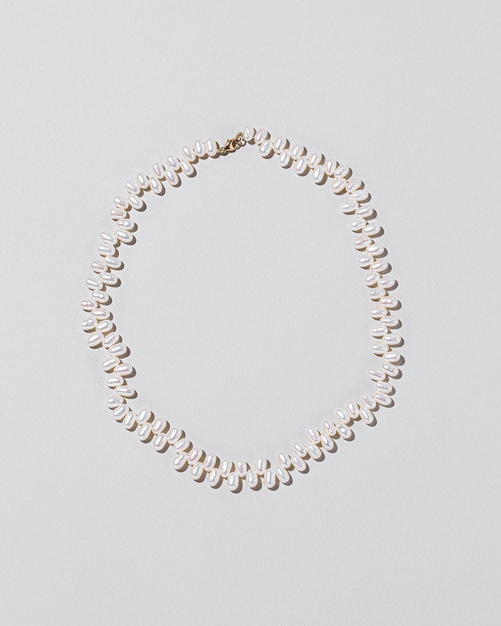 Large Zipper Pearl Necklace on light color background.
