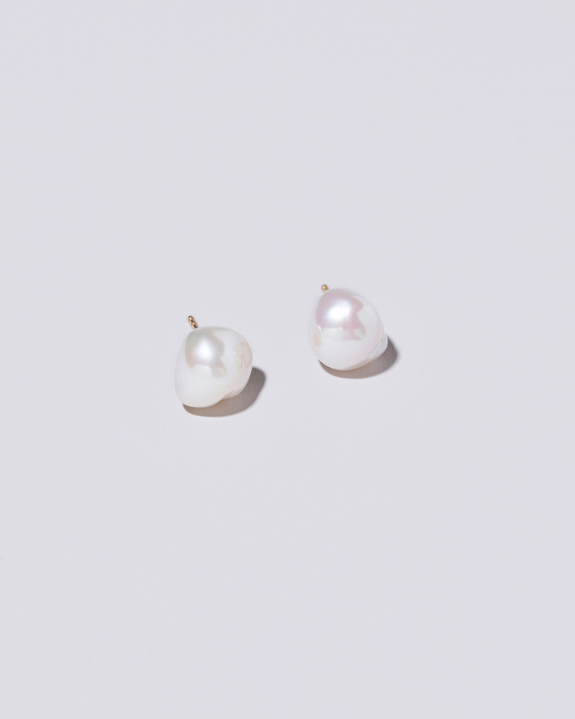 Lagniappe Pearl Stud Earrings on light colored background.