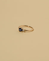 View from the side of the Blue Sapphire Teardrop Ring on light color background.