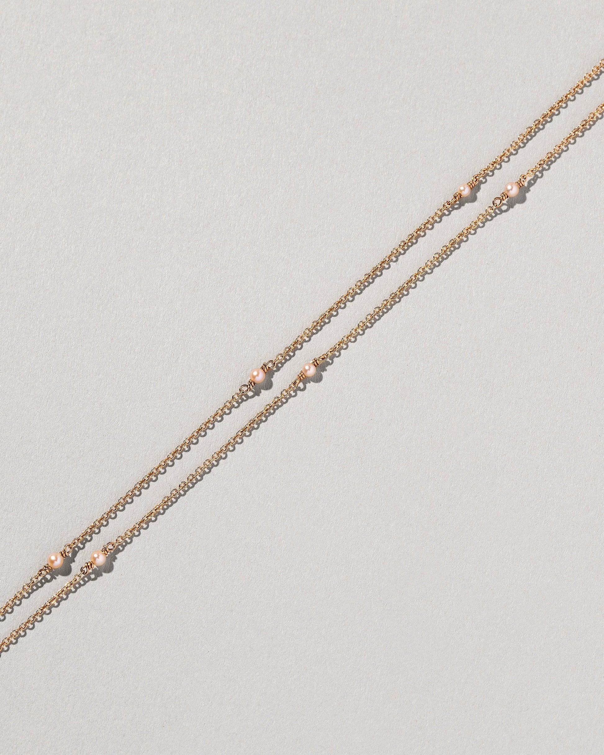 Natural Pink Seed Pearl Necklace on light color background.