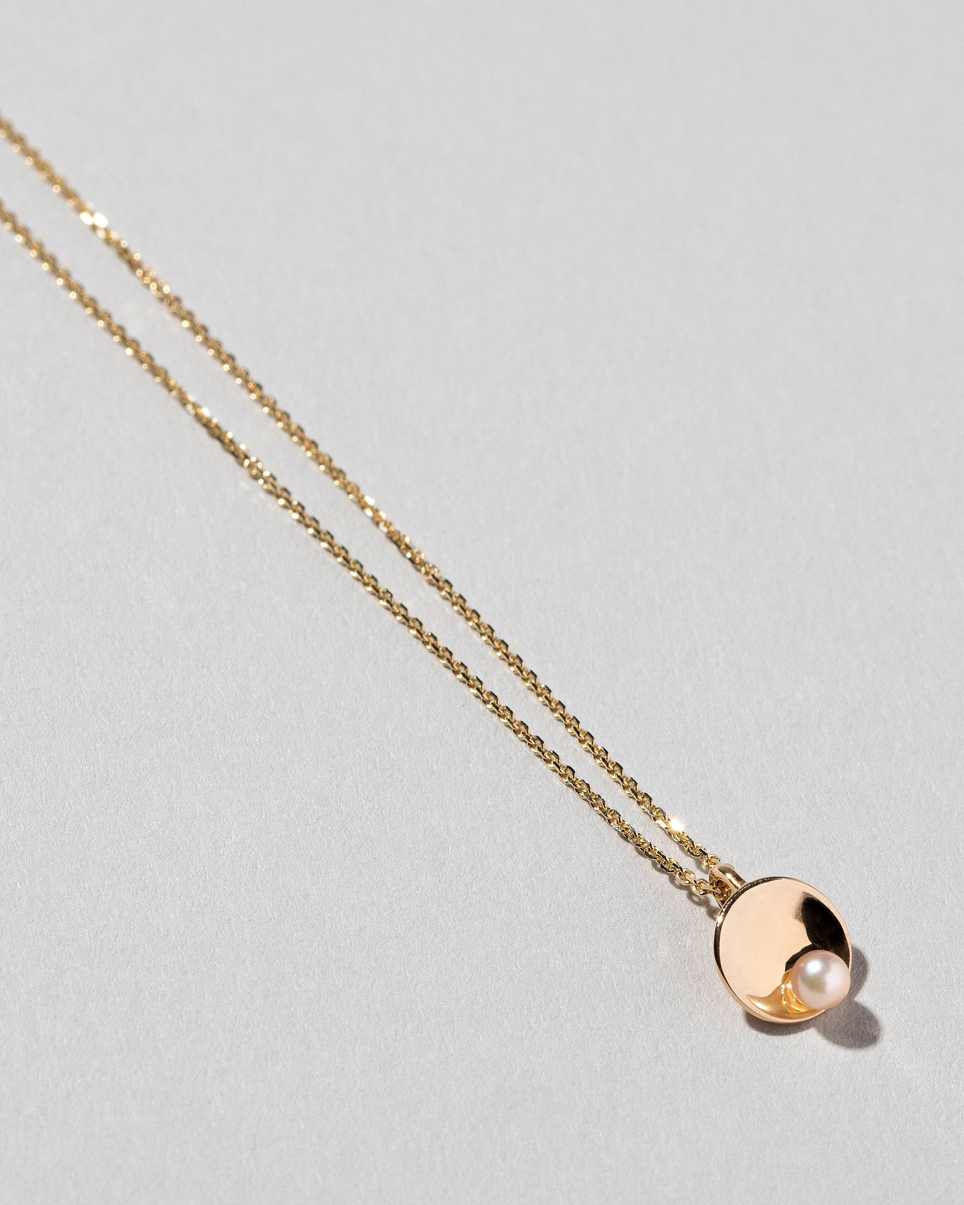 Pearl Cup Necklace on light color background.
