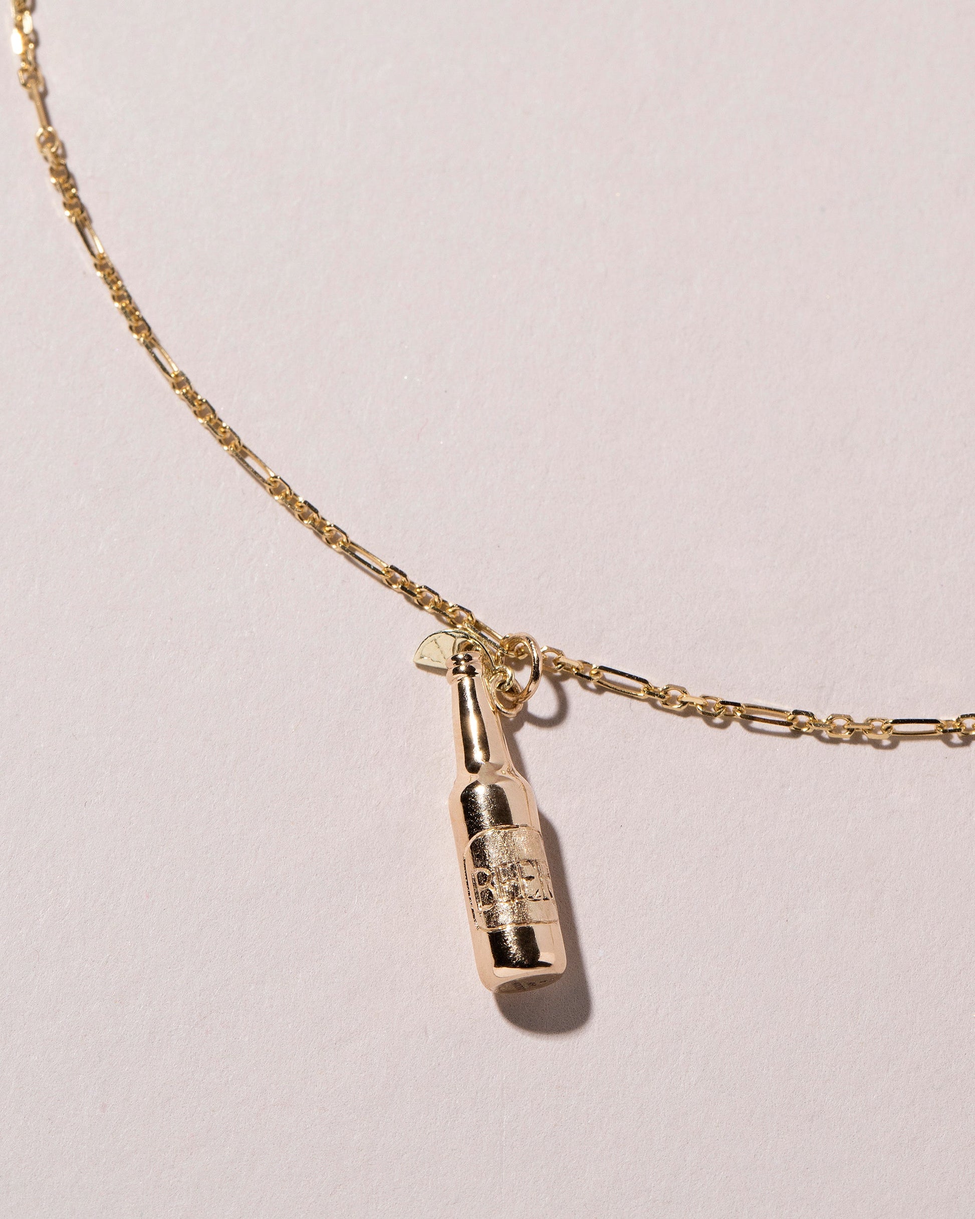 Bottle of Beer Charm on light color background.