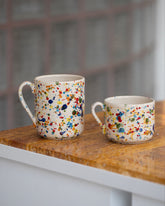 Styled image featuring the La Ceramica Vincenzo Del Monaco Colored Drops Coffee Mug and Colored Drops Tea Mug on light color background.